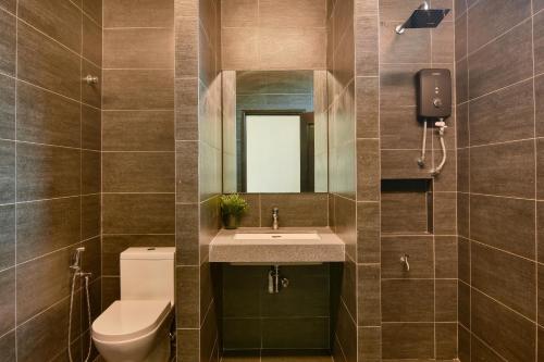 a bathroom with a sink and a toilet and a mirror at Elshape Holiday HOME in Melaka