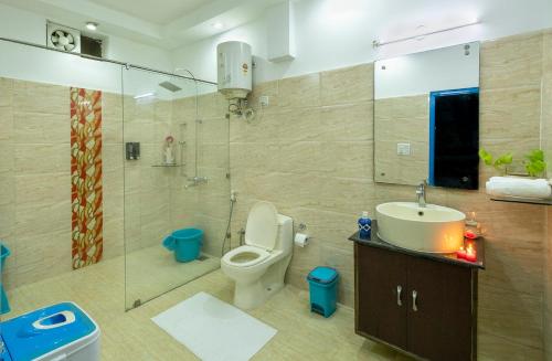 y baño con aseo, lavabo y ducha. en Sukoon Farm Stay, en Nueva Delhi