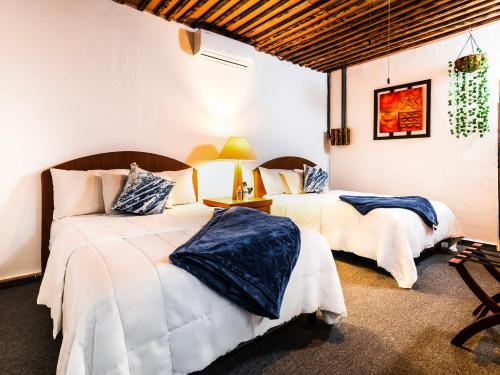 a bedroom with two beds and a table with a lamp at OYO Posada Del Pescador in Cabo San Lucas