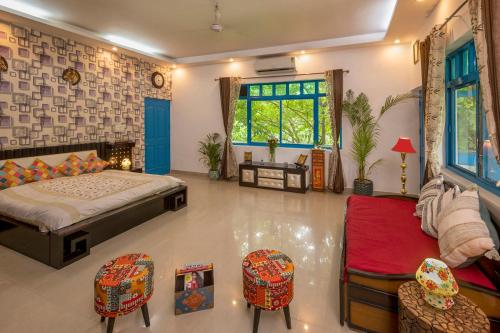 a bedroom with a bed and chairs and a window at Sukoon Farm Stay in New Delhi