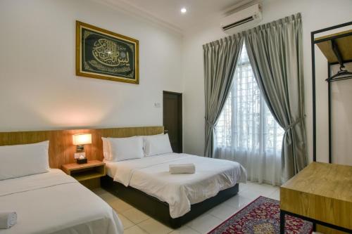 Habitación de hotel con 2 camas y ventana en Elshape Holiday HOME, en Melaka