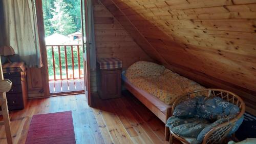 a bedroom with a bed in a log cabin at Domek drewniany u Grażynki in Kopalino