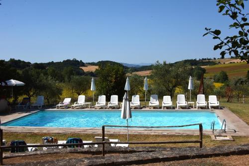 uma grande piscina com cadeiras e guarda-sóis em Agriturismo Il Geranio em Piccione