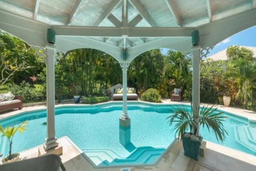 a large swimming pool with a pavilion at Rock Ridge by Barbados Sothebys International Realty in Saint Peter
