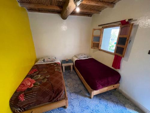 1 dormitorio con 2 literas y ventana en Auberge Chez Hassan en Imsouane
