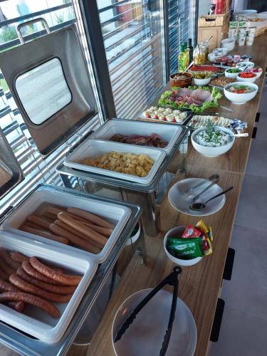a buffet line with hot dogs and other foods at Apartamenty i Pokoje Złote Piaski in Jastrzębia Góra