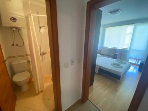 a bathroom with a toilet and a room with a bed at Kavarna Hills in Kavarna