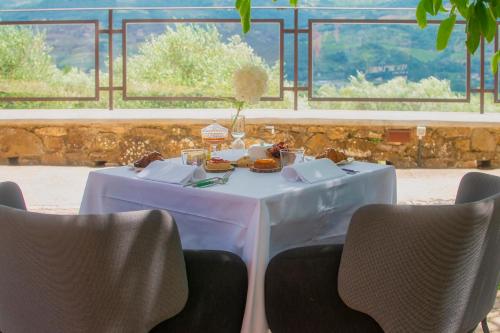- une table blanche avec de la nourriture et des chaises dans l'établissement Podere Belvedere Tuscany, à Pontassieve
