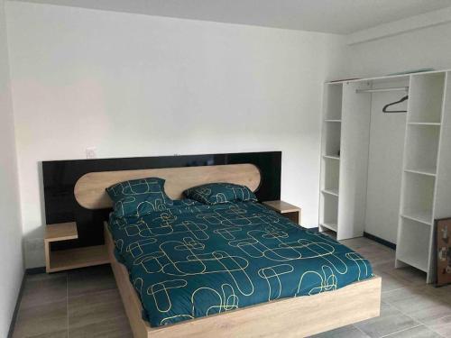 sypialnia z łóżkiem z niebieską kołdrą i poduszkami w obiekcie Chez Mélanie maison proximité du Pal w mieście Neuilly-le-Réal