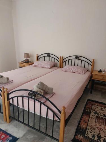 a bedroom with two beds with pink sheets at Luminosa Village Apartment in Iraklitsa