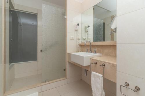 uma casa de banho com um lavatório e um chuveiro em Hotel Faranda Express Puerta del Sol Porlamar em Porlamar
