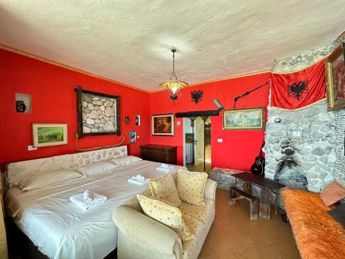 a bedroom with a large bed and red walls at Hotel Vila "Oda E Miqve" in Vlorë