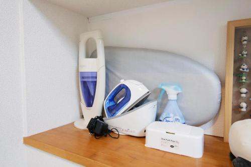 a shelf with a hair dryer and other items on it at Panda Stay Okayama in Okayama