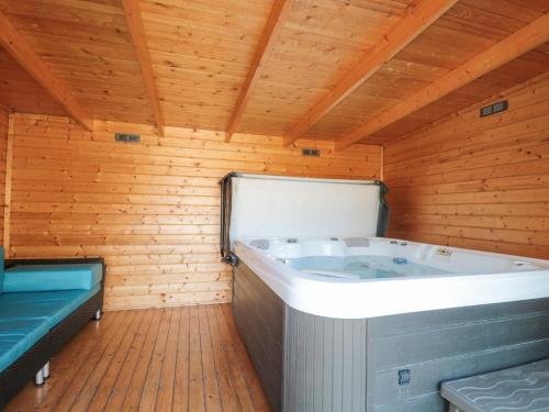 eine große Badewanne in einem Zimmer mit Holzdecke in der Unterkunft The Old Schoolrooms in Radstock