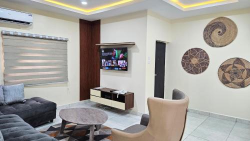 a living room with a couch and a tv at The Leneade in Abuja