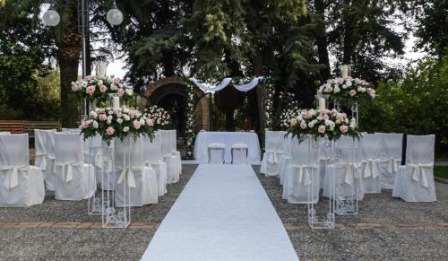 a wedding aisle with white tables and chairs and flowers at Relais Il Mulino in Corigliano Calabro