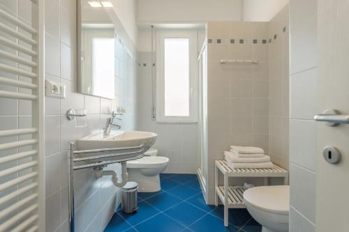 a white bathroom with a sink and a toilet at Residence Mizar in Pietra Ligure