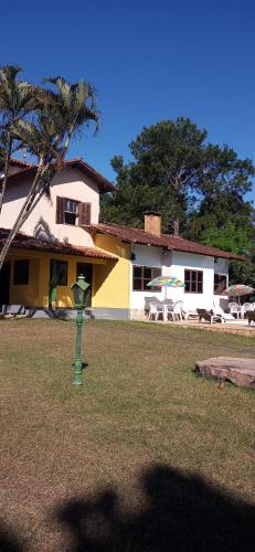 ein Haus mit einer Palme und einem grünen Objekt im Hof in der Unterkunft Pousada Chez Suomi in Penedo