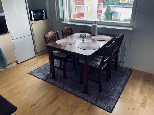 mesa de comedor con sillas y ventana en Ylimmän kerroksen kaksio Varkaudessa, en Varkaus