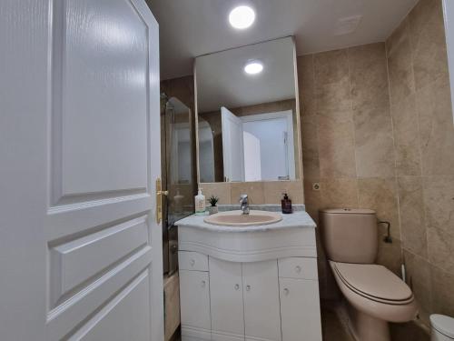 a bathroom with a sink and a toilet and a mirror at Sea Village Real in Estepona
