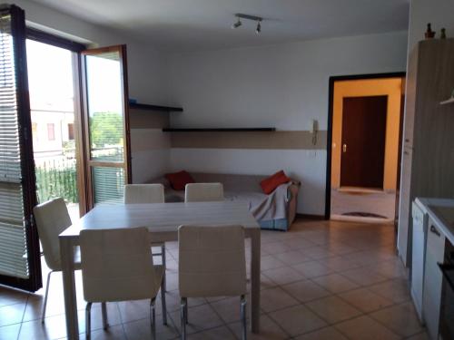 un comedor con mesa y sillas y un dormitorio en Flat Garda, en Cavalcaselle