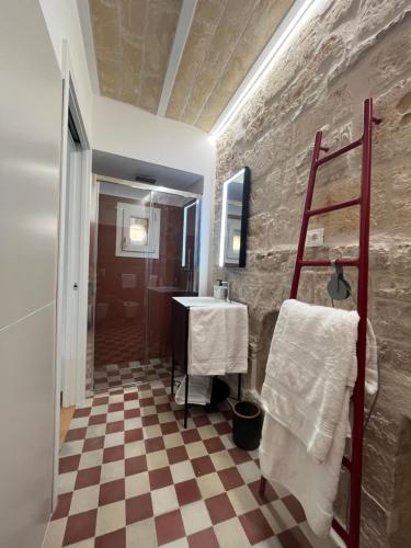 een badkamer met een geruite vloer en een wastafel bij Palazzo Lamantea Boutique Rooms in Bisceglie