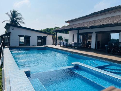 a swimming pool in front of a house at Villa Assinie Bord de Lagune in Assinie