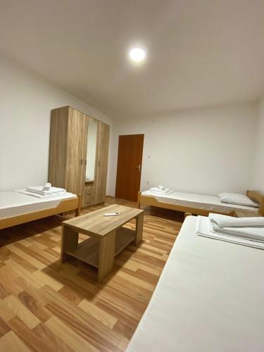 a room with two beds and a table in it at Villa Marija in Cetinje