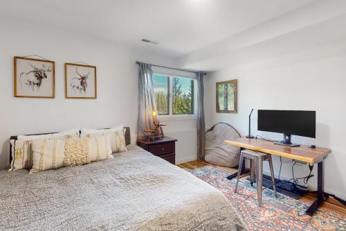 a bedroom with a bed and a desk with a television at Rainbow Connection in Tabernash