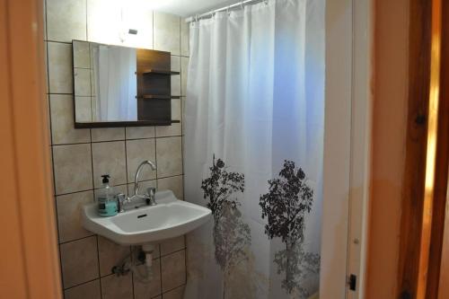 a bathroom with a sink and a shower curtain at Marathias sea view in Lákhion