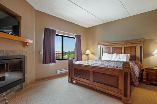 1 dormitorio con 1 cama, chimenea y TV en Chula Vista Condo 2408 en Wisconsin Dells