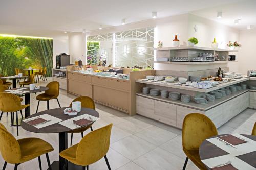 a restaurant with tables and chairs and a kitchen at PRADA' Home Eco Suites in Bardolino