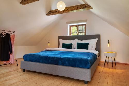 a bedroom with a large bed with a blue blanket at Kristian - House and Garden in Český Krumlov