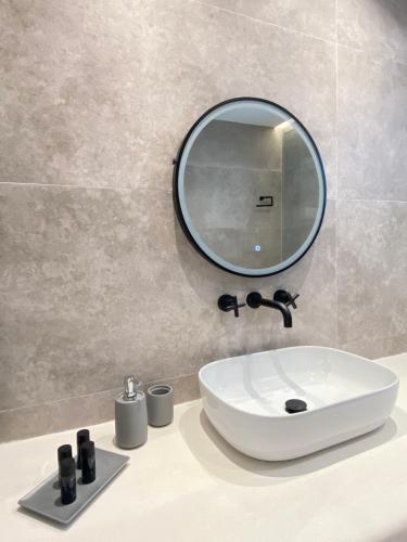 a bathroom with a sink and a mirror at Cordiale Mykonos in Ornos