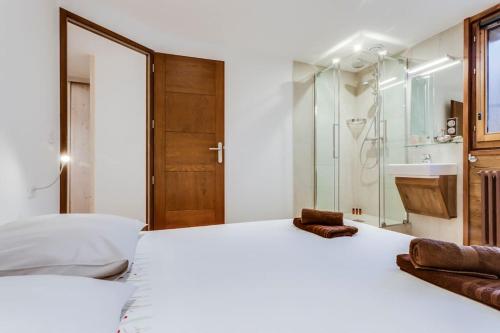 - une chambre avec un grand lit blanc et une douche dans l'établissement Magnifique trois pieces centre Val 50m des pistes, à Val dʼIsère