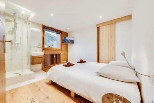 1 dormitorio con 1 cama blanca grande y ducha en Magnifique trois pieces centre Val 50m des pistes, en Val dʼIsère