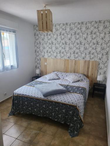 une chambre avec un lit avec une tête de lit en bois dans l'établissement Villa les pieds dans l'eau, à Le Pont du Travo