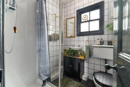 a bathroom with a toilet and a sink and a window at GuestReady - A charming stay in Highgate in London