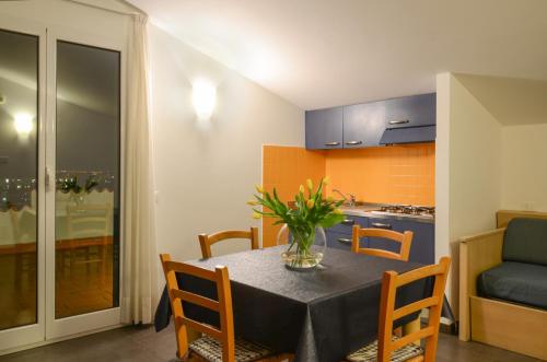 a kitchen and dining room with a table and chairs at Residence Dei Fiori in Pietra Ligure