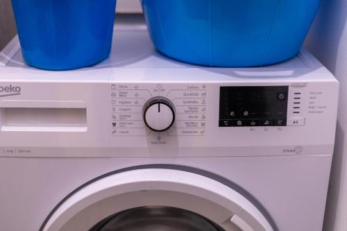 a washing machine with two blue buckets on top of it at Red Rose in Marsalforn