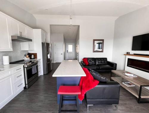 a kitchen and living room with a couch and a table at Eagle's View Penthouse in Victoria