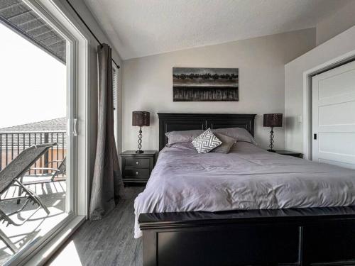 a bedroom with a large bed and a balcony at Eagle's View Penthouse in Victoria
