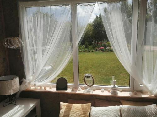 庫爾迪加的住宿－Jasmīnu aleja，客厅的窗户配有白色窗帘