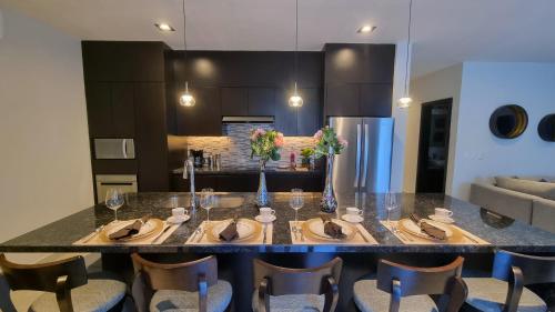 a kitchen with a large island with a table with chairs at Palacio Huatulco - 2D in Santa Maria Huatulco