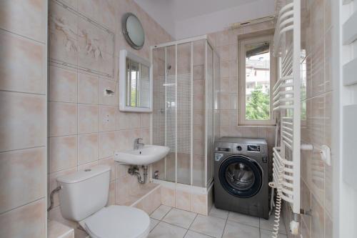 a bathroom with a washing machine and a sink at Tjiraso Apartment in Gdańsk