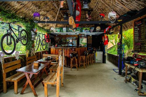 a restaurant with tables and a bar with bikes on the walls at Viñas Hotel in Lanquín