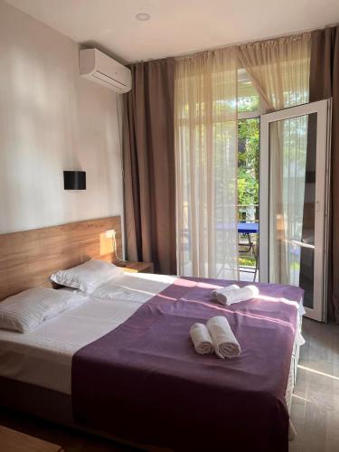 a bedroom with a large bed with two towels on it at Ef Palace Shekvetili in Shekhvetili