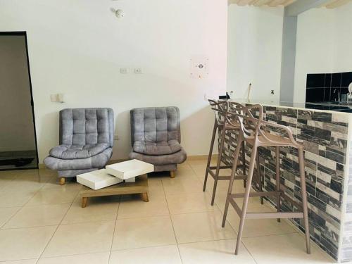 two chairs and a bar in a living room at APARTAMENTO vista VERDE DORADAL in Doradal