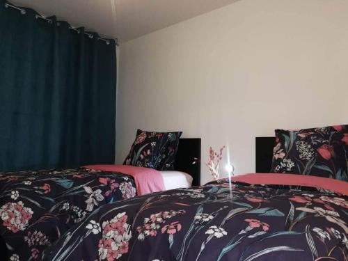 スノンにあるBel appartement familialのベッドルーム1室(花柄のシーツを使用したベッド2台付)