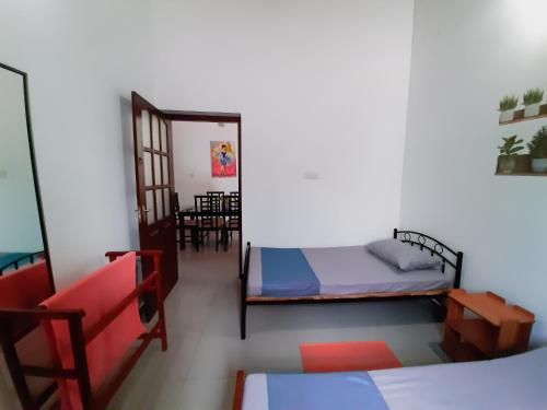 a room with two beds and a mirror at Marette Holiday Bungalow in Moratuwa